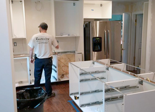 Kyle Swanson Installing Cabinets Kyle Swanson checking dimensions of kitchen cabinets